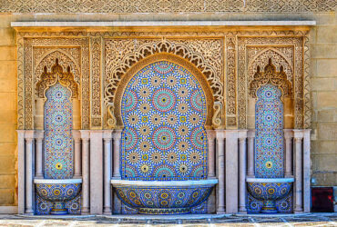A traditional moroccan fountain with three bowls.  This water feature with brass spouts is found at the King Mohammed mausoleum in Rabat, Morocco where it is decorated in a traditional moroccan style using mosaic mulit-colored tiles